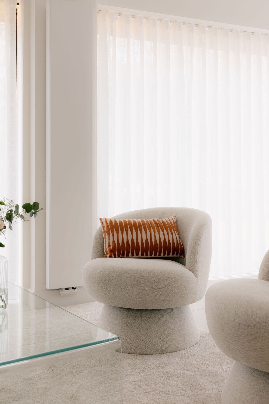 Ronde fauteuil met cognac kussen voor lichte gordijnen