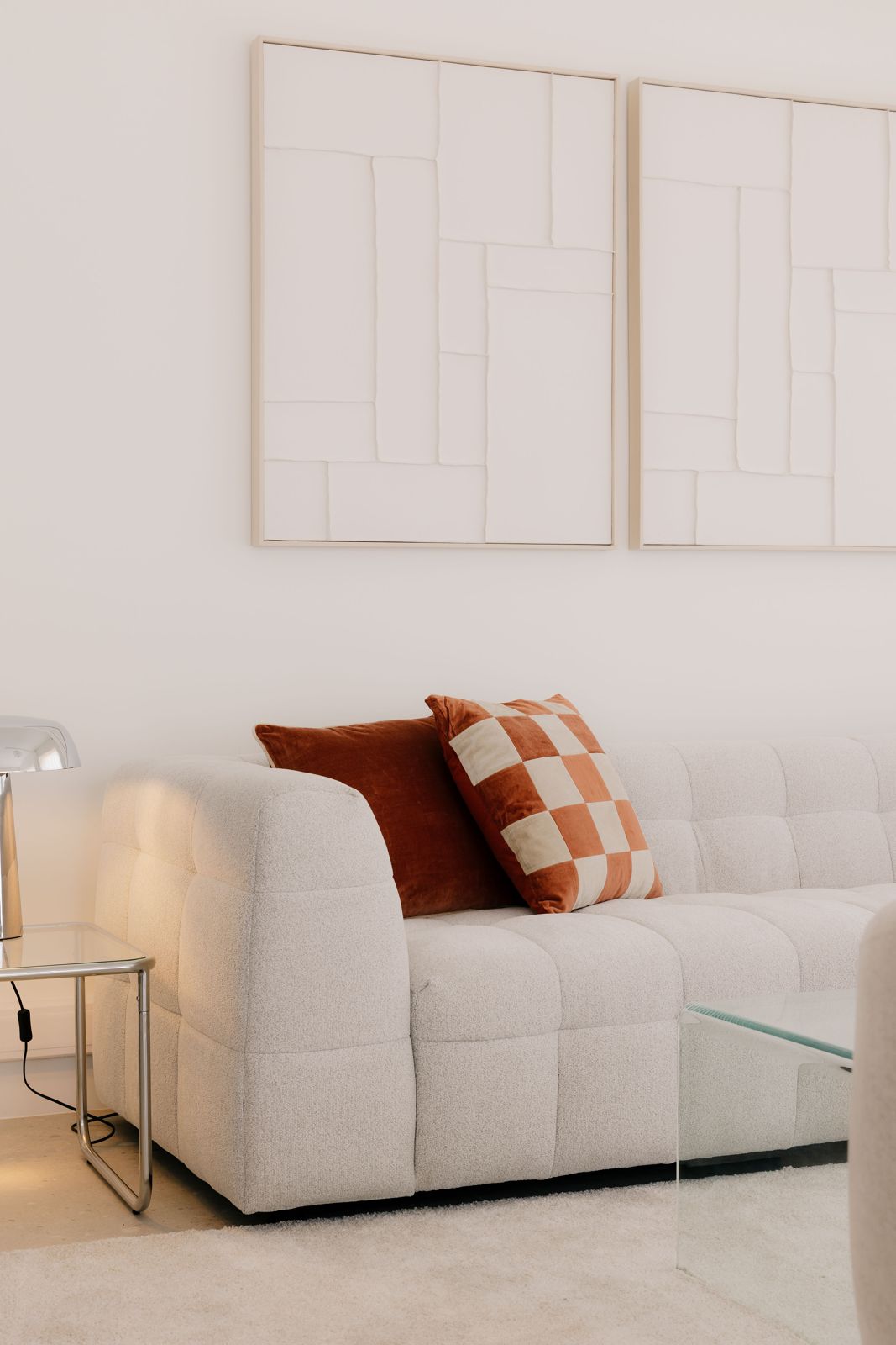 Lichte zetel met cognac fluwelen kussens en reliëfkunst aan de muur