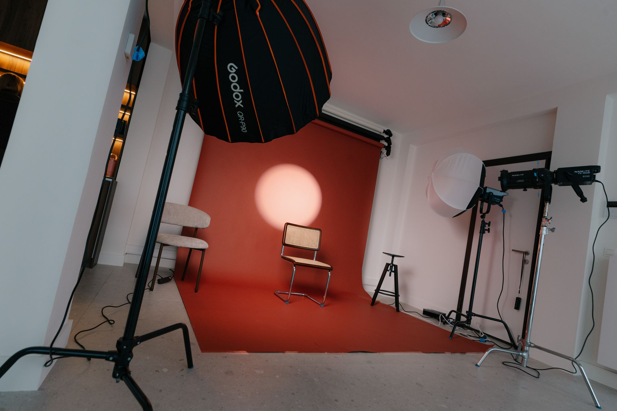 Fotostudio met rode backdrop, parabolische softbox en studiolampen